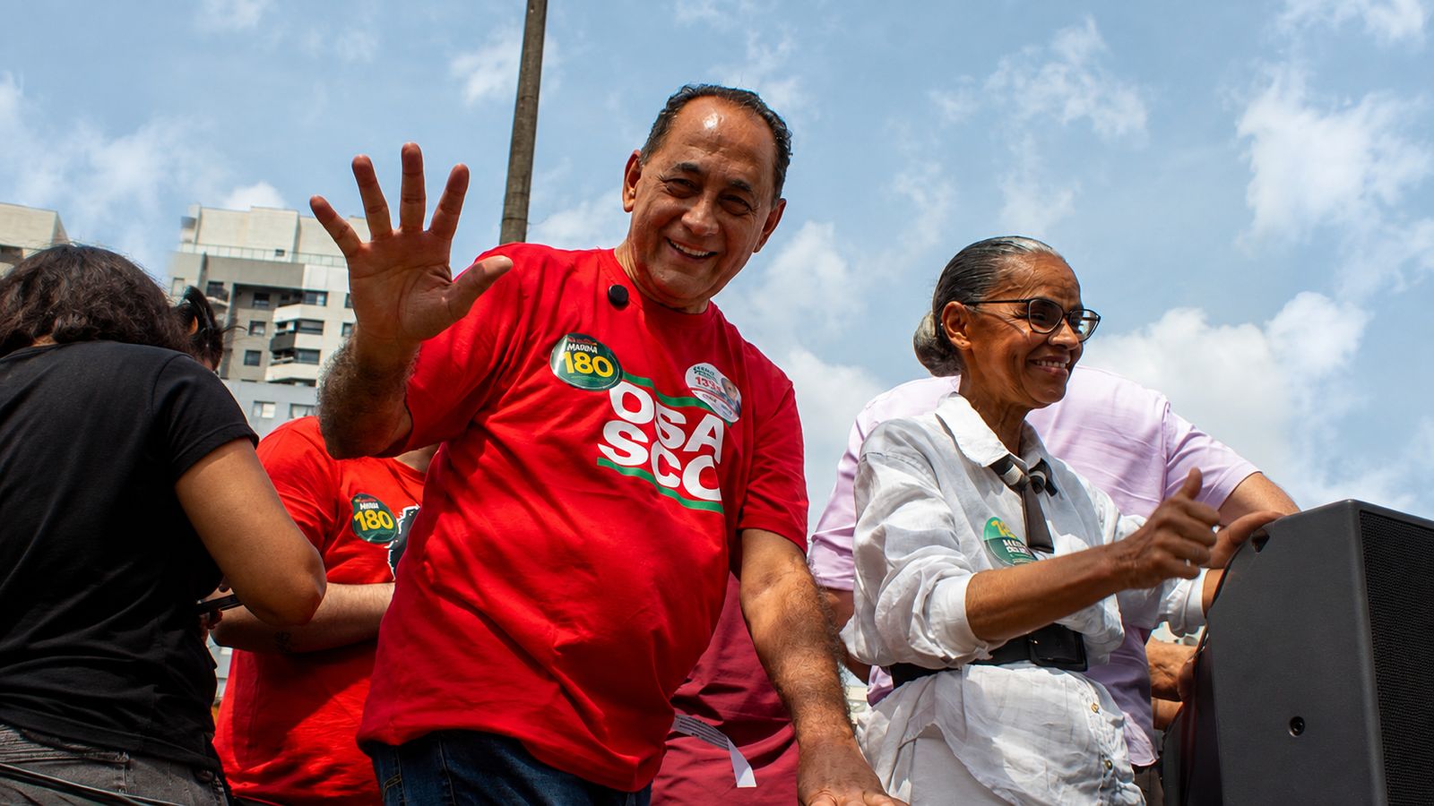 João Paulo, de camiseta vermelha, acena para o público durante caminhada em Osasco, ao lado de Marina Silva.