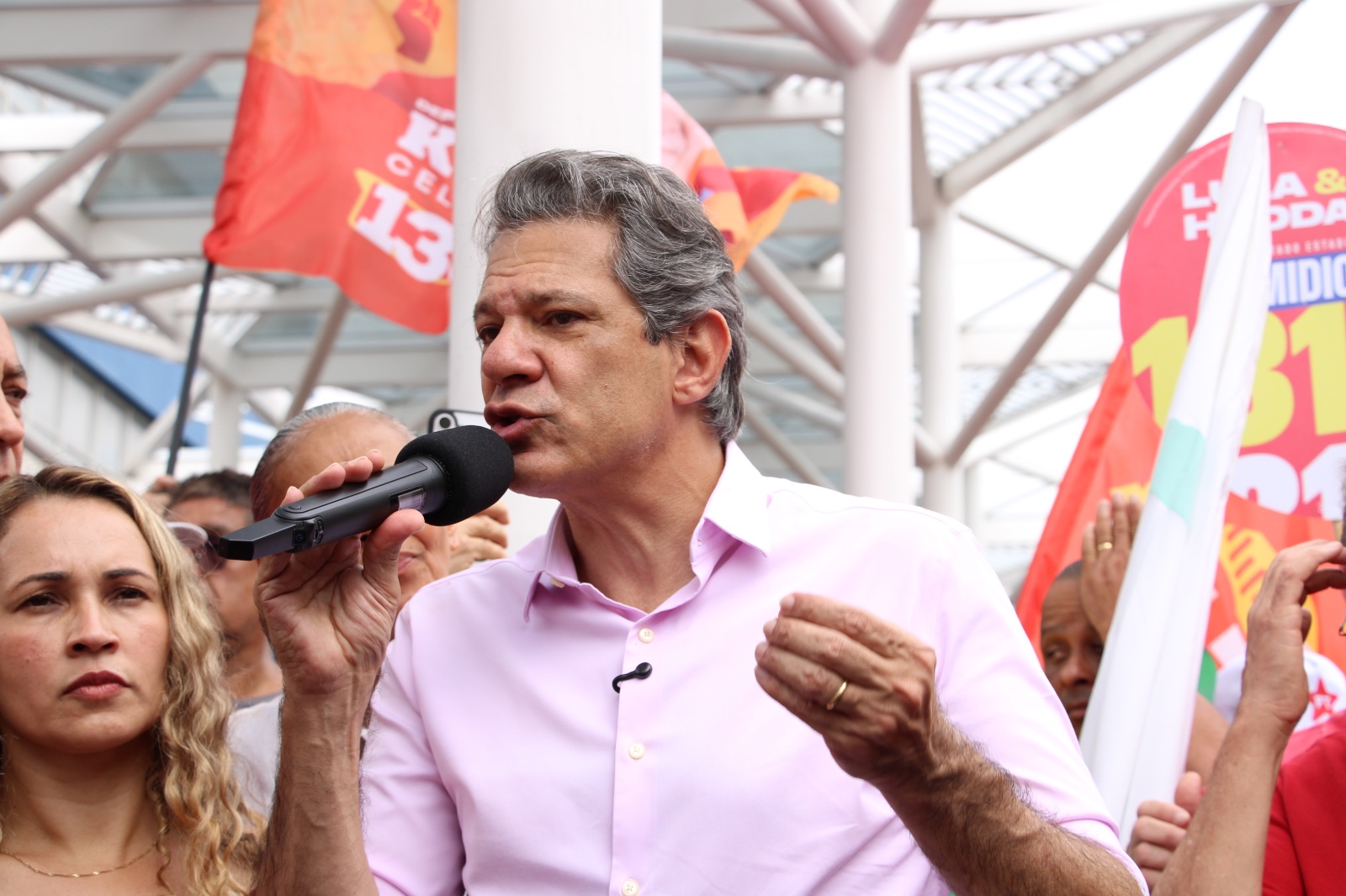 Fernando Haddad fala ao microfone durante a mobilização do PT em Osasco, cercado por apoiadores e bandeiras.