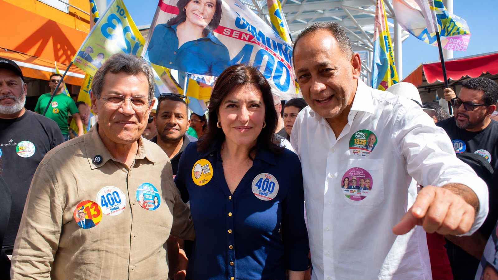 Simone Tebet e João Paulo Cunha aparecem lado a lado durante caminhada política em Osasco, acompanhados de apoiadores e outras lideranças.